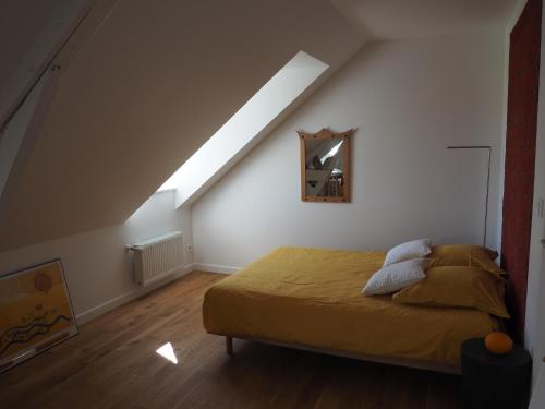 a bedroom with a bed and a skylight at Entre en Baie ! in Pontaubault