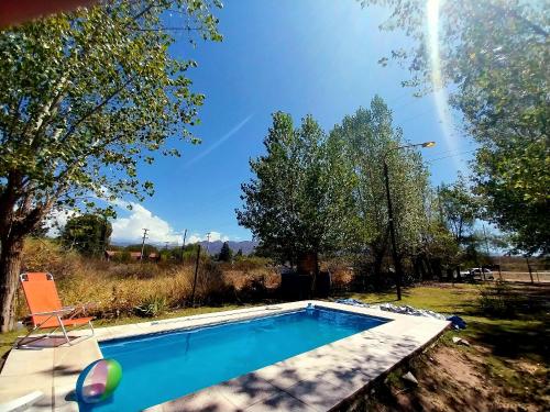 a swimming pool in a yard with a chair at La Pepita in Ciudad Lujan de Cuyo