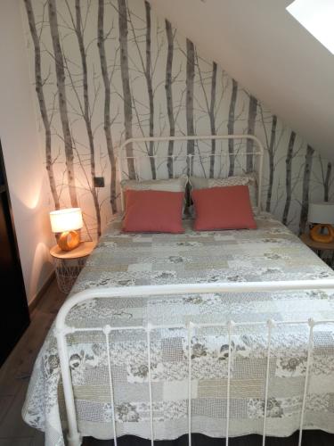 een slaapkamer met een wit bed en 2 rode kussens bij La châtre in Ronthon