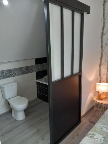 een badkamer met een toilet en een zwarte deur bij La châtre in Ronthon