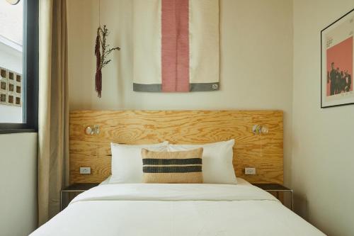 a bedroom with a white bed with a wooden headboard at APT by DW in San Juan