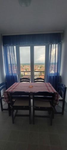 mesa y sillas en una habitación con ventana grande en Stan sa poogledom na grad en Paraćin