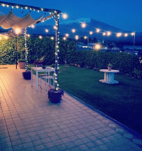 a patio with a table and a tent with lights at Good Morning Etna in Bronte