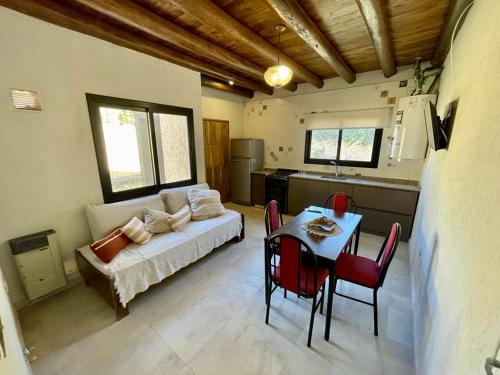 a living room with a bed and a table with chairs at Los Aromos'home in Chacras de Coria