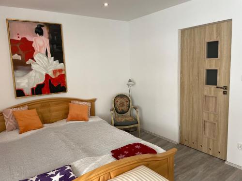 布羅德尼察的住宿－Cichy Zaułek 5 i 6，卧室配有一张床,墙上挂有绘画作品