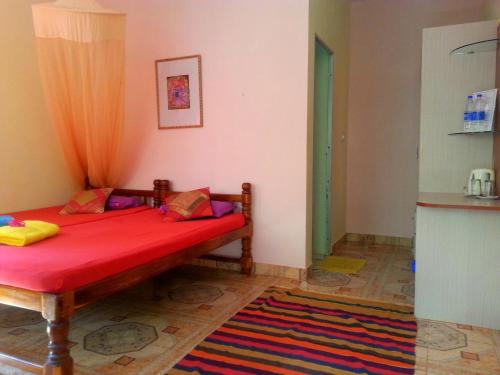 a bedroom with a red bed in a room at Namaste Yoga Farm in Gokarna