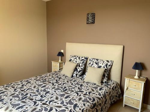 um quarto com uma cama com almofadas e duas mesas de cabeceira em Villa Madou em Rochefort-du-Gard