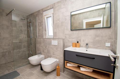 a bathroom with a sink and a toilet and a mirror at Villa Mina with a private pool in Pula in Pula