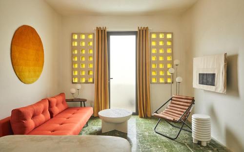 a living room with an orange couch and a chair at APT by DW in San Juan