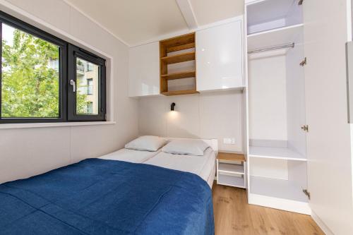 een kleine slaapkamer met een bed en een raam bij Domki Letniskowe Plaża II in Sianozety