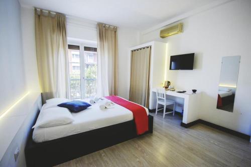 1 dormitorio con cama y escritorio. en Centro Città Concept, en Bari
