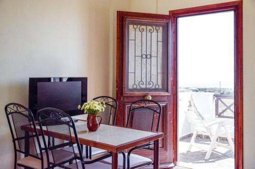 a dining room with a table and chairs and a television at Το Μεγάλο Αμπέλι in Megalokhori