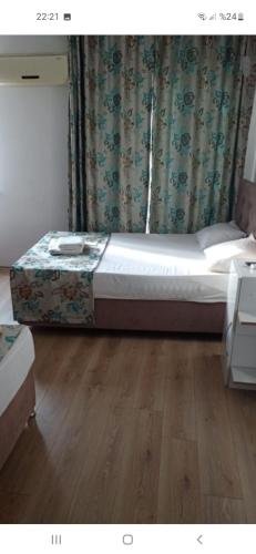 1 dormitorio con 1 cama y suelo de madera en Kınay pansiyon, en Belek