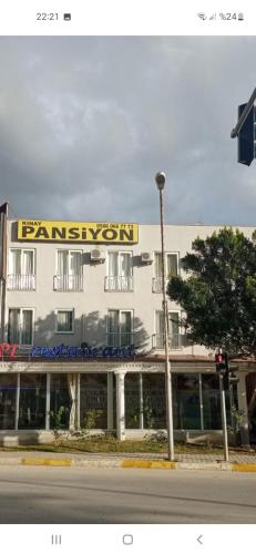 un gran edificio blanco con un cartel encima en Kınay pansiyon, en Belek