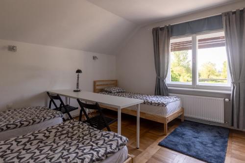 a room with two beds and a table and a window at Apartment Bogomila in Ljubljana