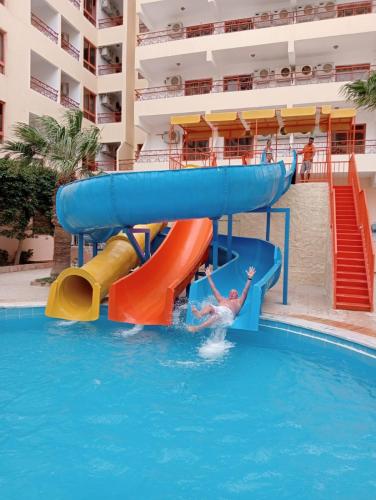 a person on a water slide in a swimming pool at Empire Hotel Aqua Park - Couples and Families in Hurghada
