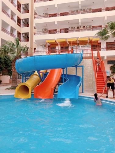 a water slide in the pool at a resort at Empire Hotel Aqua Park - Couples and Families in Hurghada