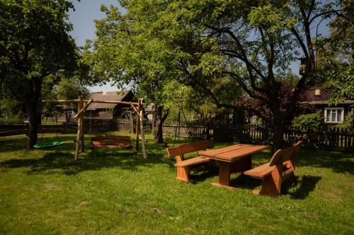 un parc avec une table de pique-nique en bois et une aire de jeux dans l'établissement Groszkówka 2, à Narewka