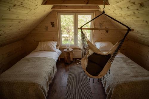 - une chambre avec 2 lits et un hamac dans une cabine dans l'établissement Groszkówka 2, à Narewka