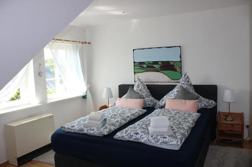 ノルトシュトラントにあるReetdachhaus Deichkroneのベッドルーム(ブルーベッド1台、枕付)