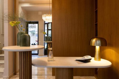 Cette chambre comprend une table avec un vase et une lampe. dans l'établissement Taodomus Small Boutique Hotel, à Taormine