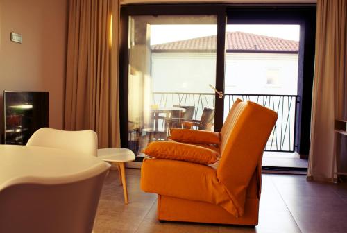 a living room with an orange chair and a balcony at LeNo in Umag