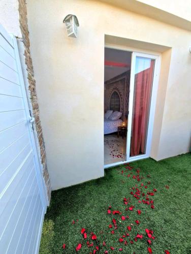 a pile of red flowers on the grass next to a house at Suite jaccuzzi en camargue in Saint-Louis-du-Rhône
