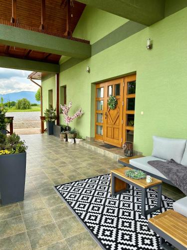a green house with a couch and a table at Apartmán Ranč in Martin