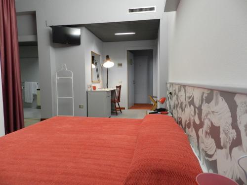 a bedroom with a bed with a red blanket at Hotel Italia in Stradella