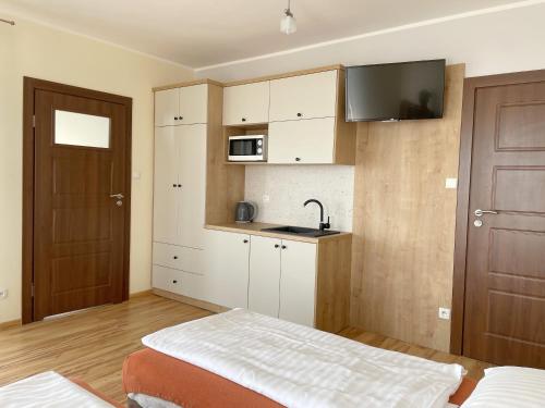 um pequeno quarto com uma cama e uma cozinha em Willa Jaskółka em Władysławowo