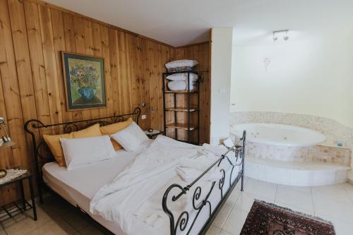 1 dormitorio con cama y bañera en צימר בלוטים באמנון, en Amnon