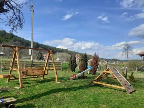un parque infantil con un columpio y un tobogán en Kuca Karajic, en Užice