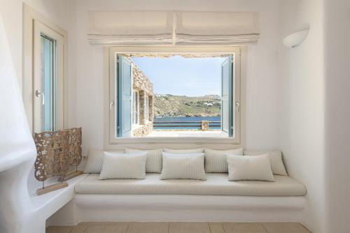a window seat in a room with a view of the ocean at Etesians Suites & Villas in Super Paradise Beach