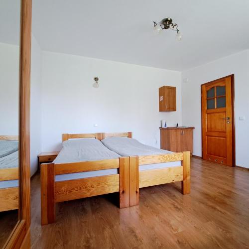 a bedroom with a bed and a wooden floor at Domek letniskowy Smreczyny Bobra in Jeziorko