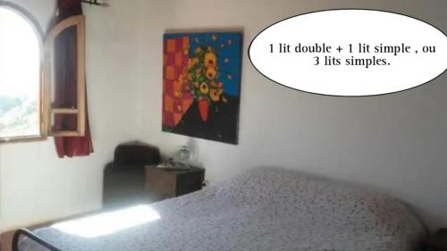 a bedroom with a bed and a painting on the wall at Auberge Village Paradise Valley in Tagherat Anekrim