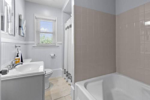 a white bathroom with a tub and a sink at Hargett Street Villa in Raleigh