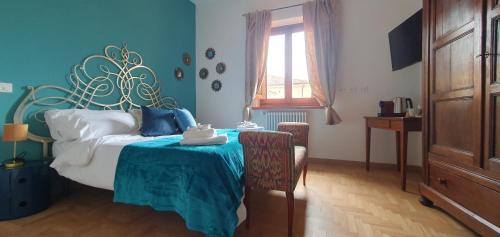 Schlafzimmer mit einem Bett, einem Tisch und einem Fenster in der Unterkunft Argonauti Rooms Retreat in Pistoia