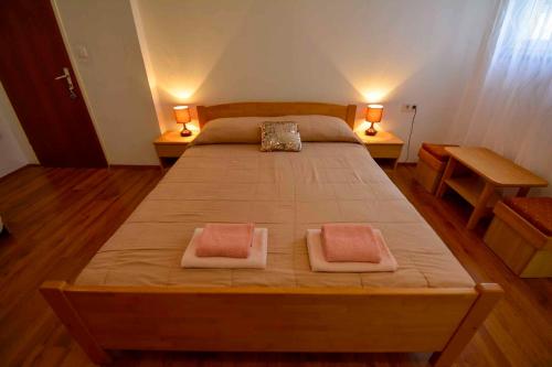 um quarto com uma cama grande com duas almofadas em Apartment in Banjol/Insel Rab 26609 em Banjol