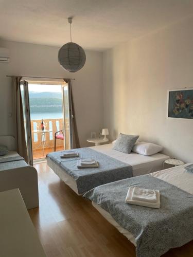 two beds in a room with a view of the ocean at Apartments Ela in Neum