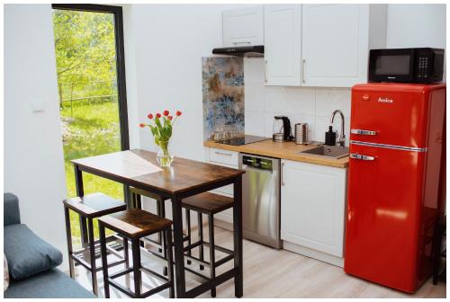 een keuken met een rode koelkast en een tafel en stoelen bij Enklava in Szramowo