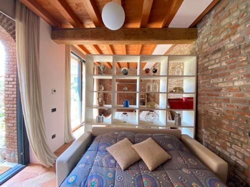 a bedroom with a bed and a brick wall at Borgo Archinto in Robecco sul Naviglio