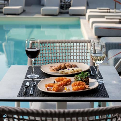 a table with two plates of food and two glasses of wine at Casa Bloo Adults Only in Elia