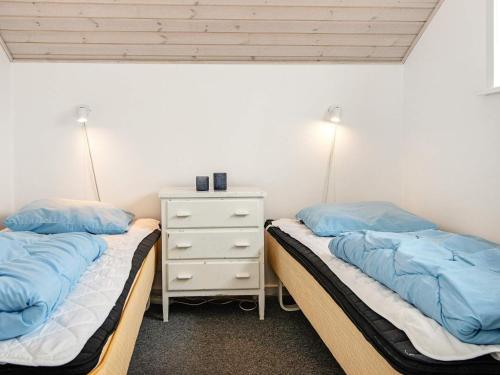 a bedroom with two beds and a night stand at Holiday Home As Hedegård II in Sønderby