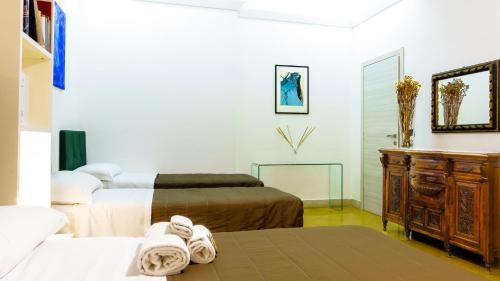 um quarto com 2 camas, uma cómoda e um espelho em Suite in Center em Palermo