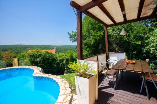 patio ze stołem i basenem w obiekcie Holiday Home Deborah with Private Pool w mieście Labin
