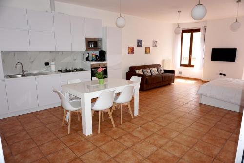 eine Küche und ein Wohnzimmer mit einem weißen Tisch und Stühlen in der Unterkunft Appartamento in piazza CAVOUR centro storico Rimini in Rimini