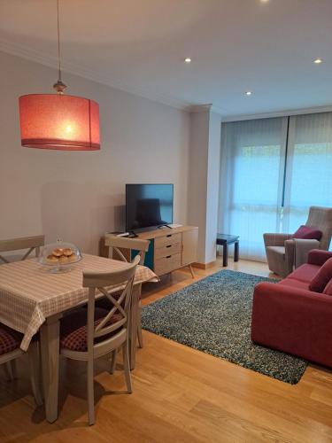 a living room with a table and a red couch at Apartamento en el centro con garaje directo. in Bilbao