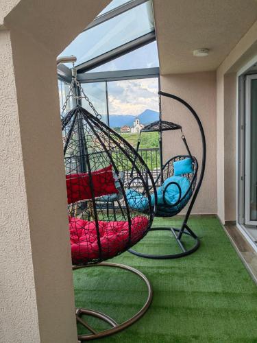 a swing in front of a window on a porch at Apartment Lukavica in Lukavica