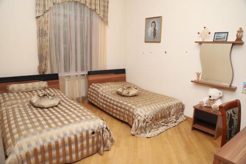 1 Schlafzimmer mit 2 Betten, einem Tisch und einem Spiegel in der Unterkunft Eriks guest house in Goris