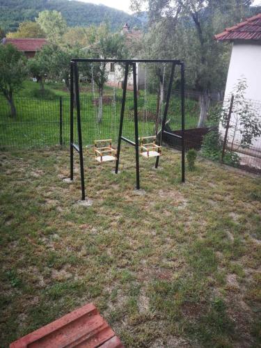 an empty swing set in a yard at Odmaralište Vlaško ždrelo in Pirot